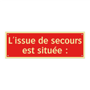L'issue de secours est située :