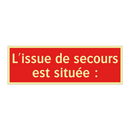 L'issue de secours est située :