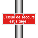 L'issue de secours est située :