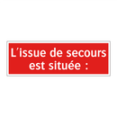 L'issue de secours est située :