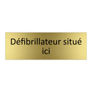Défibrillateur situé ici